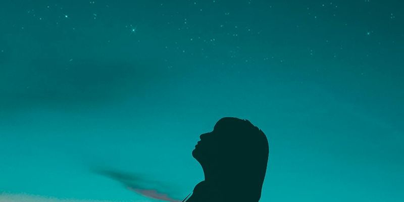 Silhouette of a pregnant woman against a sunset sky.